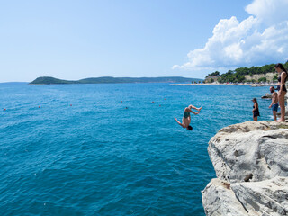Turistas saltando de las rocas en la costa de Split, Croacia, verano de 2019 © acaballero67