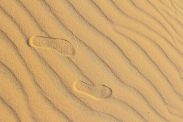 Fototapeta na wymiar Footprints are stepping on sand , small step to future step has background