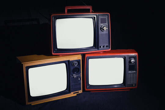 Three Old Antique TV With White Screen In A Dark Room, Classic, Vintage, Television On A Black Background.