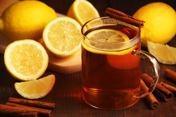 A mug with hot tea with lemons and cinnamon sticks