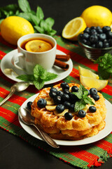Belgian waffles with blueberry and a cup of tea with lemon