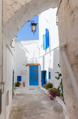 Typical view of Ostuni with houses with white walls and blue window frames. Stone buildings with southern Italy style.