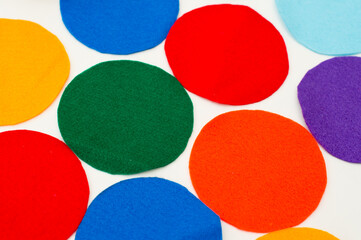 Colored felt circles on white background.