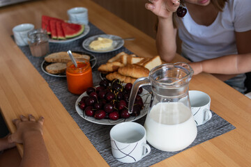 Mother and daughters enjoying a full breakfast together in the kitchen.