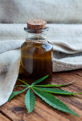 hemp oil and leaves on a wooden table