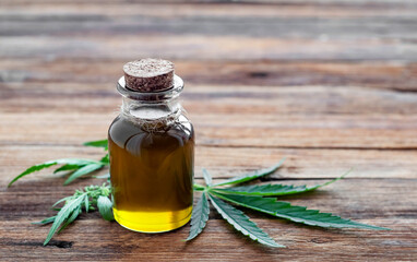 hemp oil and leaves on a wooden table
