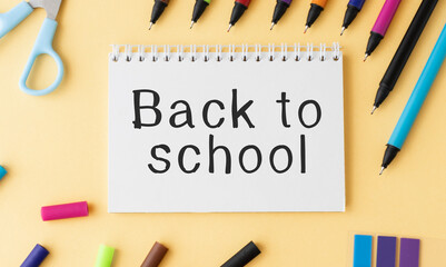 Back to school text sign on notepad with pencil and wooden plain school rulers around. Stationery and eco friendly school supplies.