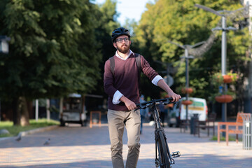 Portrait of a male commuter wearing bike helmet in a town. Safe cycling in city, bicycle commuting, active urban lifestyle image