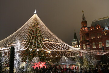 Journey to Christmas Festival 2020 in Moscow city, Russia. New Year decor, Christmas decoration on street. New Year fir-tree with light garland on Manezhnaya Square at night