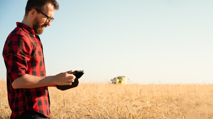 Portrait of a man with tablet lin a wheat or rye field. Modern farmer, agriculture business management, local business owner concept