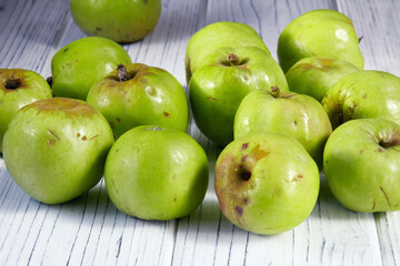 Green apples on a wooden surface.