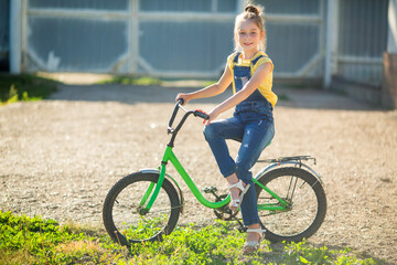 beautiful teenage girl riding a bicycle in summer