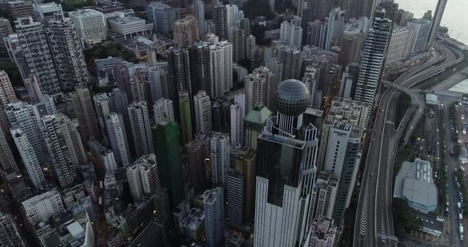 4K UHD car traffic and people crossing road in Hong Kong city downtown. Drone aerial top view, fly upward. Commuter, Asia city life or public transportation concept
