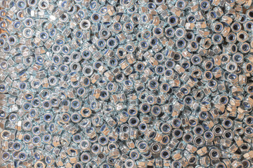 Fototapeta premium Nuts. Texture. A lot of rubberized nuts for bolts and screws. Background for wallpaper. Female screw. Screw-nut. Internal screw.