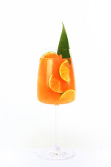 Lemonade of oranges and limes in a tall glass glass. Vertical photo on a light background. Copy of the space.Isolated object