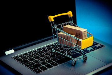 Paper boxes in shopping cart on notebook keyboard. Shopping Online / e-commerce or electronic...