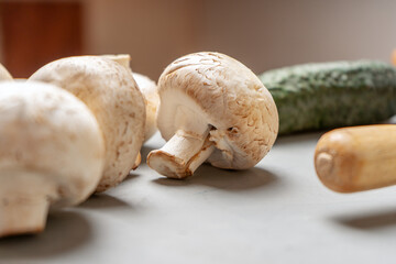 Mushrooms on the kitchen table near the rolling pin and cucumber