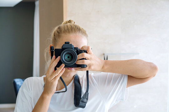 Female photographer taking selfie in the mirror