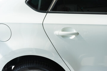 side rear of a new white car at the showroom. rear side door and door handle