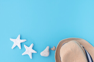 starfish and straw hat a blue background. Concept of travel