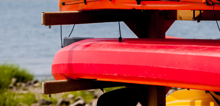 Kayaks stacked outdoor on beach - Powered by Adobe