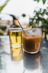 iced coffee with milk and hot tea in Vietnamese style on table. Selective Focus.