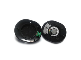 Opened black color over the ear headphone with circuit board and internal magnet on white background