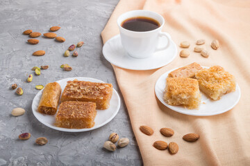 traditional arabic sweets and a cup of coffee on a gray concrete background. side view, close up.