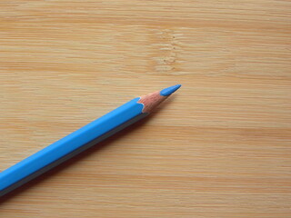 Blue color pencil kept on wooden table