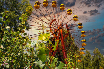 Iconic pripyat ferris wheel in the exclusion zone on a golden red sunset in the summer. Red almost...