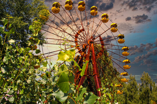 Iconic pripyat ferris wheel in the exclusion zone on a golden red sunset in the summer. Red almost burning sky indicating recent forest and wildfires
