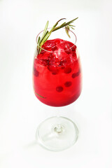 Cranberry lemonade in a tall glass glass. The drink is decorated with a sprig of rosemary. Photo on a light background. An isolated object. Copy of the space.
