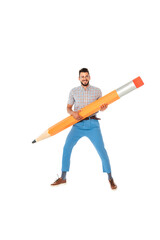 Positive nerd in eyeglasses smiling at camera while holding huge pencil isolated on white