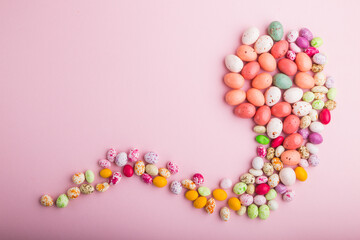Colorful multicolored candies on a pink pastel background. copy space, top view.