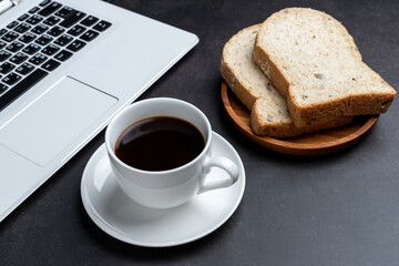 Laptop,coffee, and bread on table desk. View from above with copy space