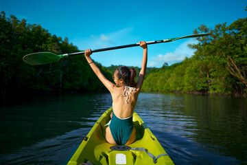 Women who are kayaking and raising hands are happy.