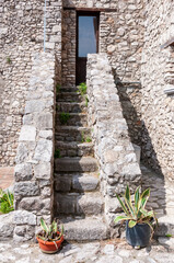 A narrow street between the old houses of a medieval village in Riardo Italy