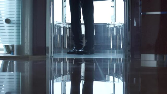 Man in suit and black shoes entering into the modern elevator. Elevator's doors open male legs in black shoes enter into the elevator.