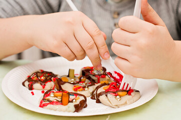 Kid decorating play dough pancakes.