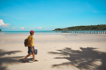    The traveler is traveling on the beach and looking at the beautiful sea.
