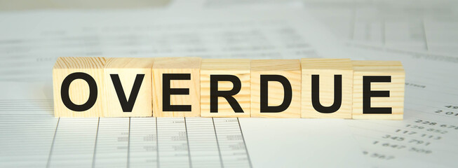 text overdue written on cubes and financial statements. financing