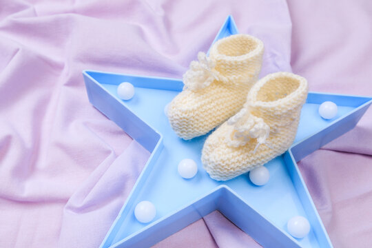 crumpled fabric lilac fleece background  with star shaped night light and baby booties - Image