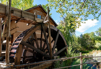 Fototapeta na wymiar Old Wooden Water Wheel to Grain Mill on a Sunny Fall Day