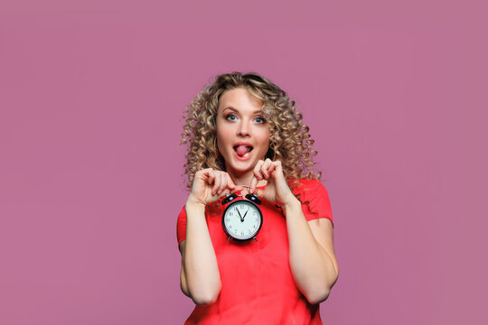 beautiful young woman   with curl hair  posing  on pink   background  with clock - Image