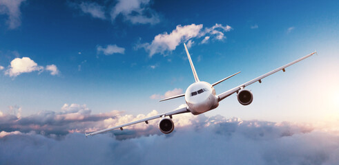 Fototapeta premium Samolot komercyjny lecący nad chmurami