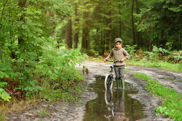 5 years old boy is having fun in the forest. The active child is riding a bicycle. Active recreation.
