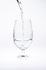 Pour water in glass isolated on white background.