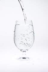 Pour water in glass isolated on white background.