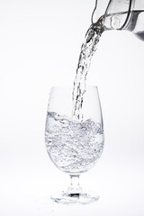 Pour water in glass isolated on white background.