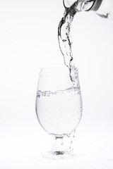 Pour water in glass isolated on white background.